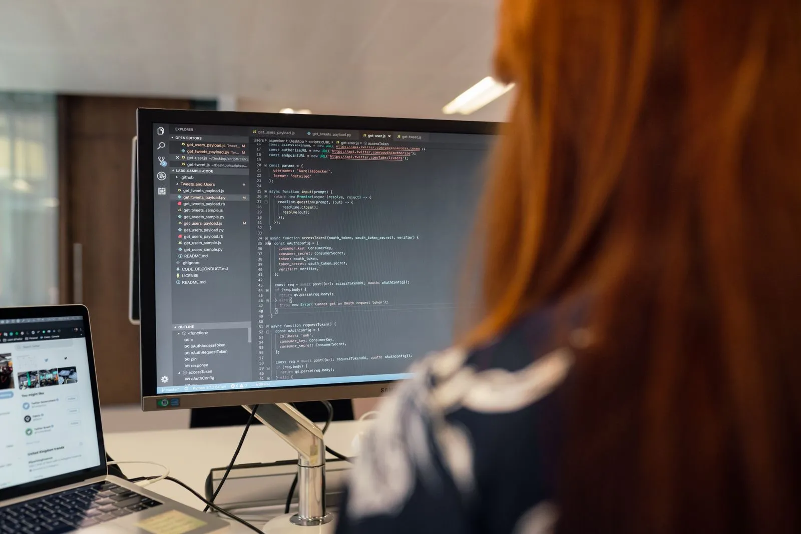 Woman writing code on a large monitor, working in one of many AI careers