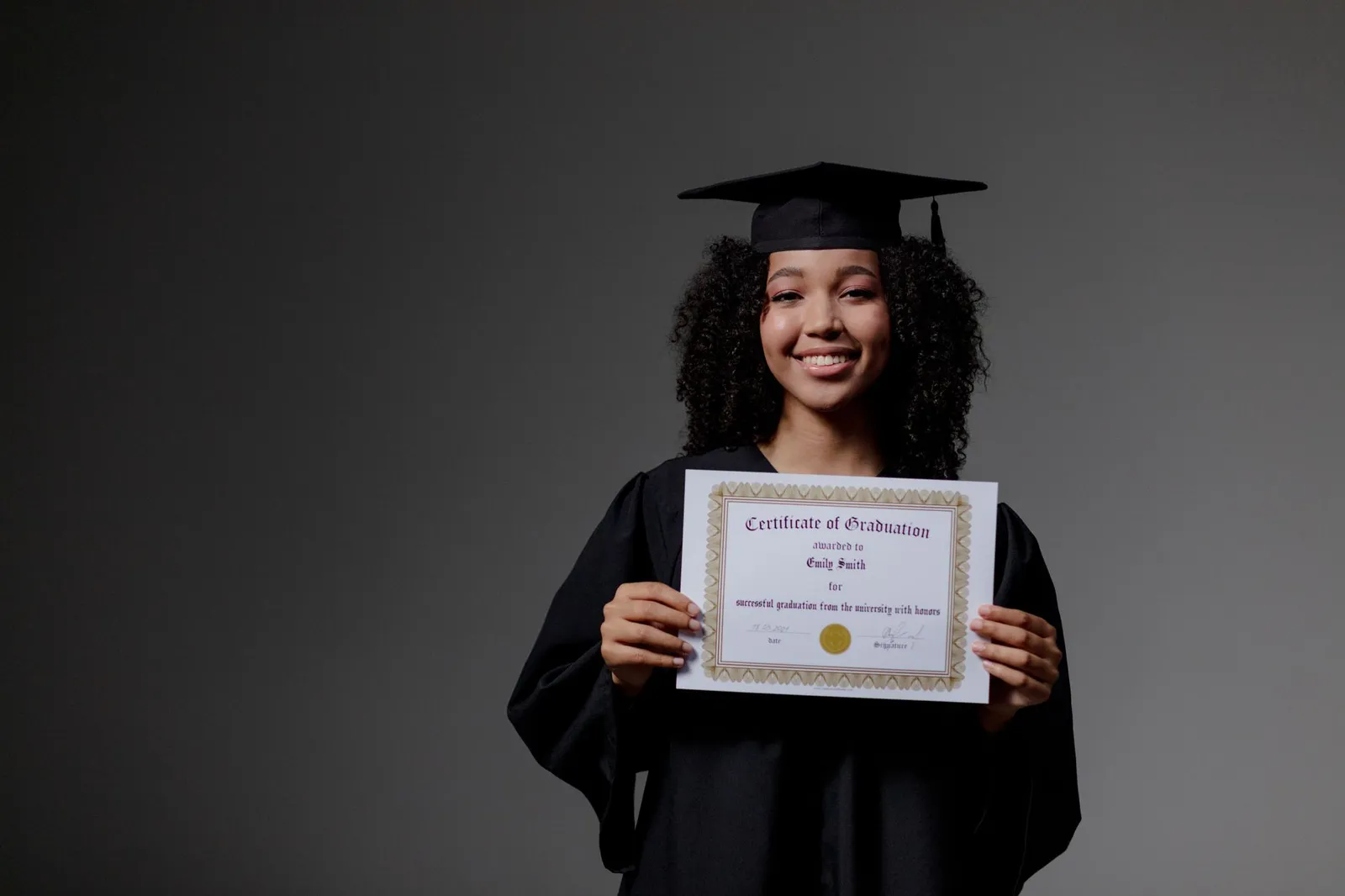 Smiling graduate in cap and gown holding up a certificate after earning an AI credential
