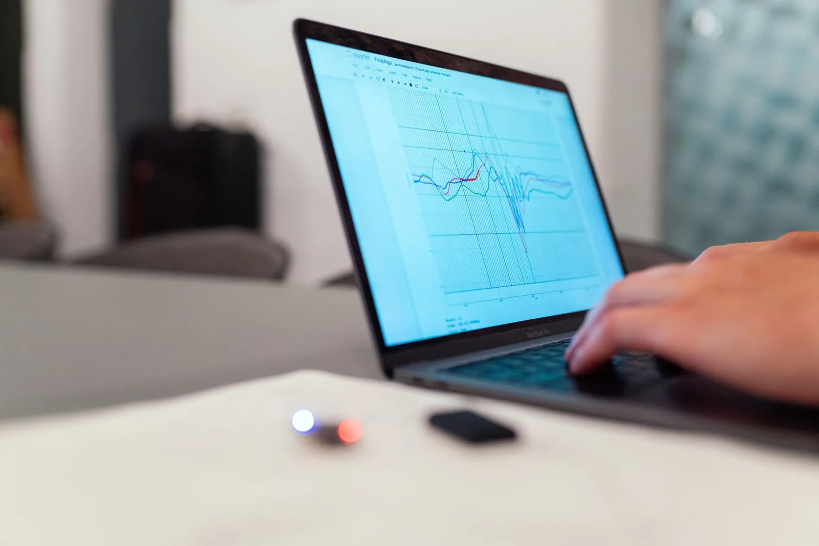 Data scientist typing in a Jupyter notebook with a multicolored line plot