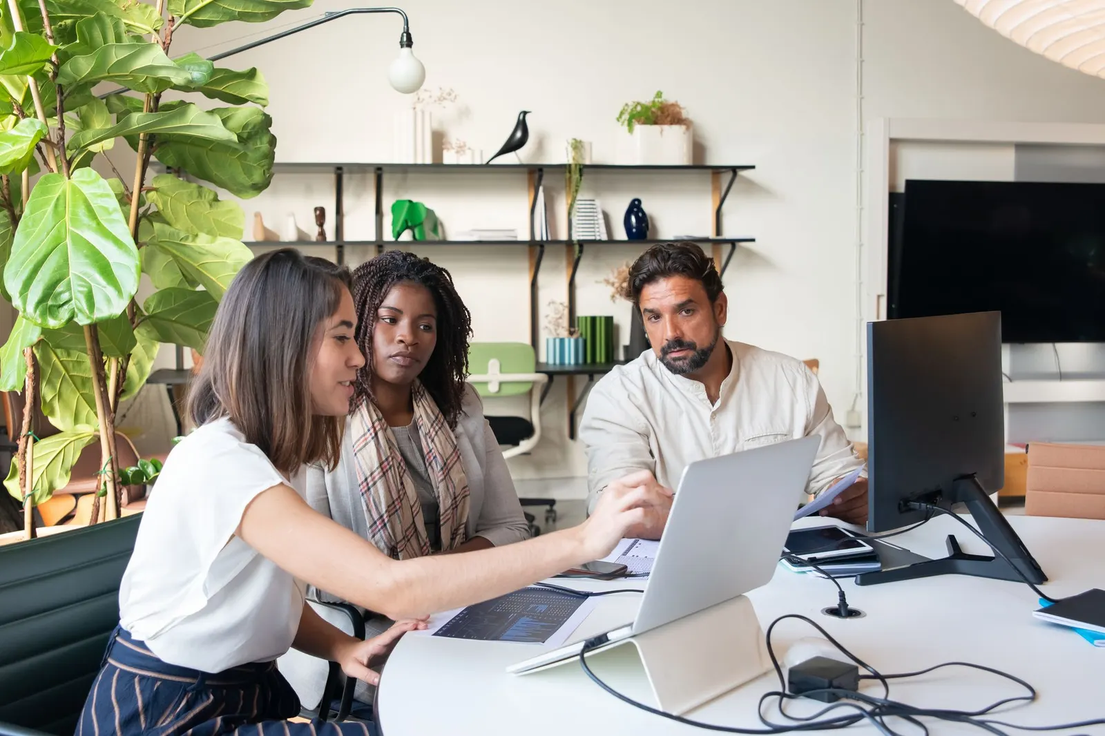 Managers at a laptop discussing generative AI, the focus of Google's Generative AI Leader certification