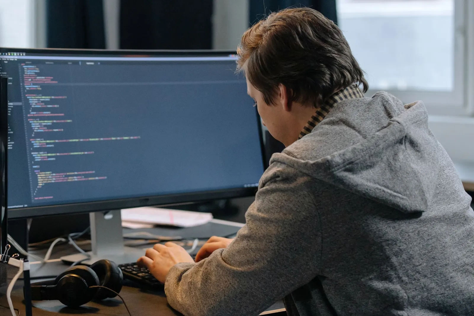 Developer typing at a monitor full of colored code, preparing for the AI-102 exam