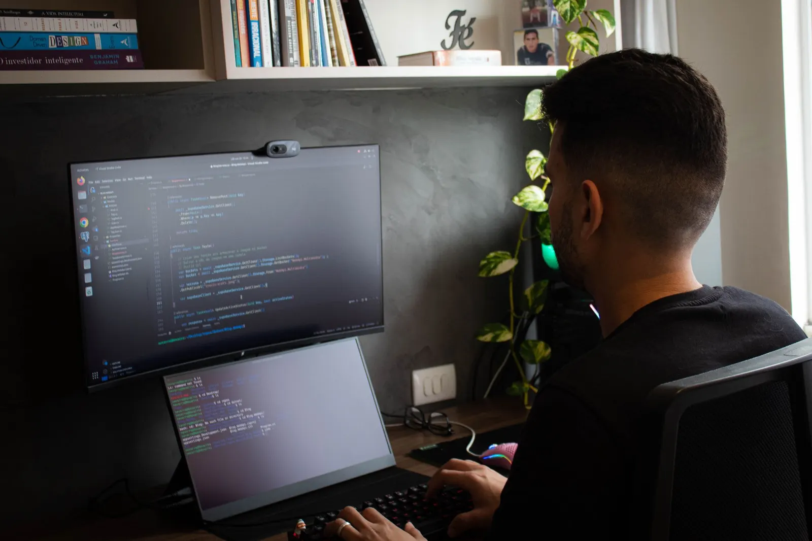 Man coding on a large monitor above a laptop, preparing for an NVIDIA AI certification